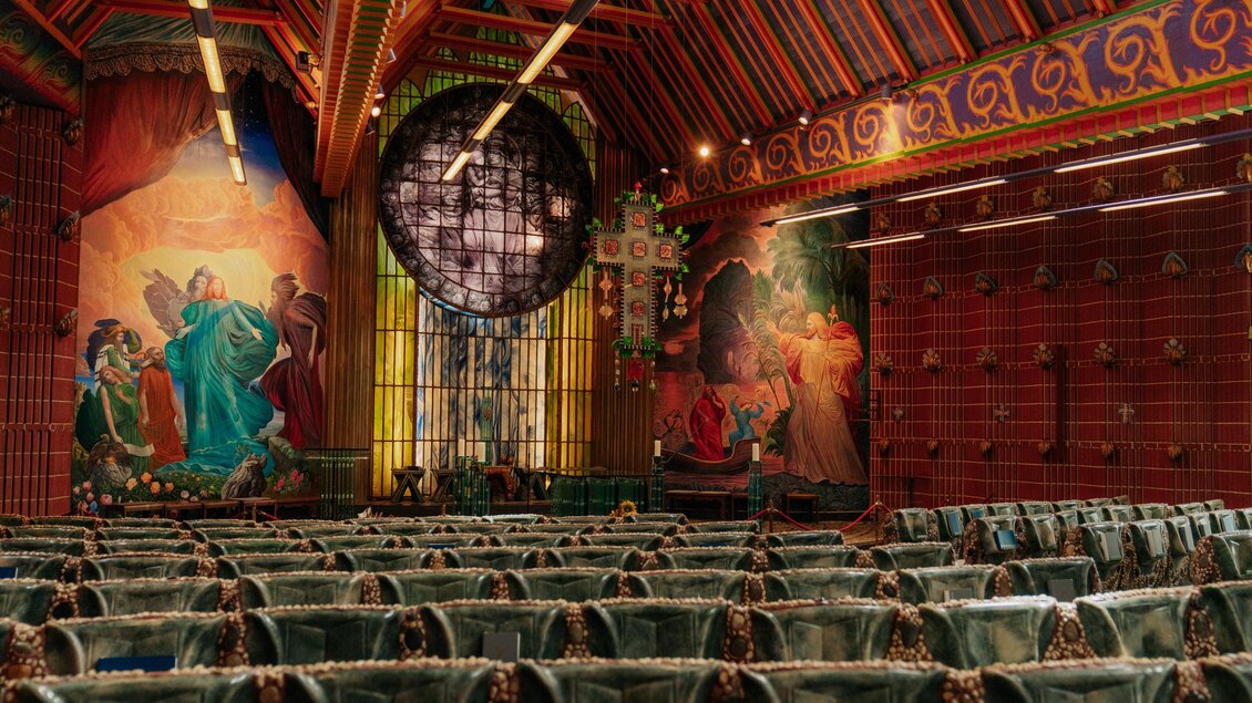 Ein reich dekorierter Veranstaltungssaal mit bunten Wandmalereien. Die Bestuhlung ist in einem traditionellen Stil gehalten und schafft eine einladende Atmosphäre. | © (c) Region Graz - studio draussen