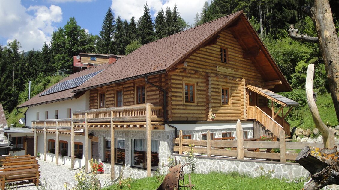 Ein schönes Holzhaus inmitten von grünen Landschaften. Die Terrasse und der Balkon bieten einen perfekten Blick auf die Natur.