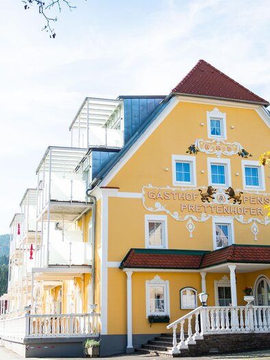 Man sieht eine Flasche Sekt mit zwei Gläsern und im Hintergrund eine schön Aussicht in die Natur.  | © Jogllandhotel Prettenhofer
