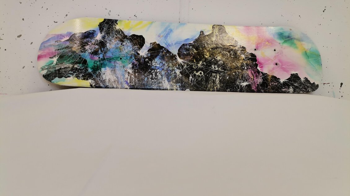 Ein bunt gestaltetes Snowboard mit abstrakten Mustern in Schwarz, Blau, und vielen anderen Farben. Der Hintergrund ist weiß, was die Farben hervorhebt. | © Julia Hauck