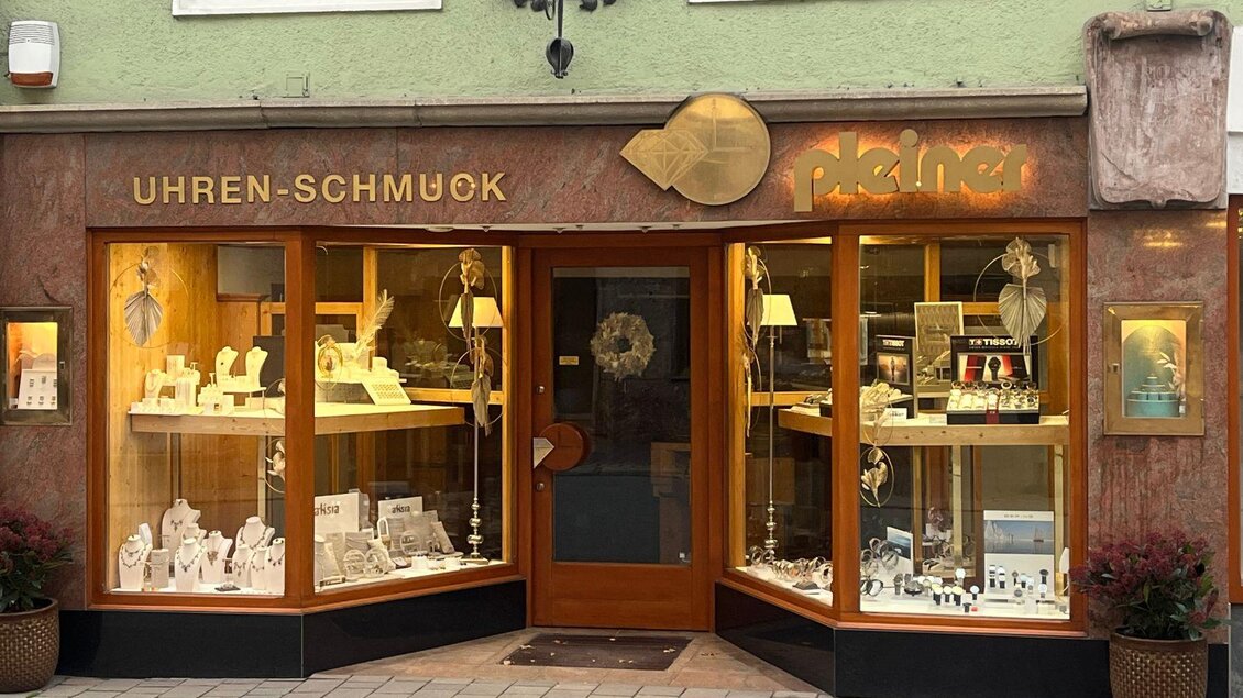 Eine elegante Halskette mit mehreren Kettensträngen und einem auffälligen Anhänger. Die Schmuckstücke sind von einer lilafarbenen Bluse und einem bunten Schal umrahmt. | © TVB Ausseerland Salzkammergut_Nathalie Schröttenhamer