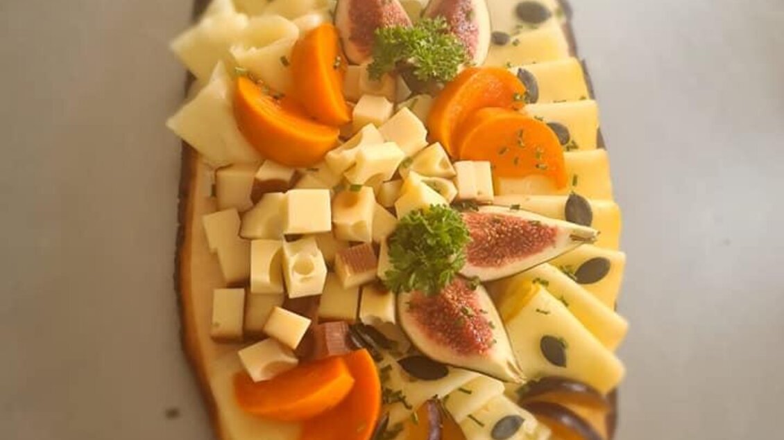 Ein kunstvoll angerichtetes Käsebrett mit verschiedenen Käsesorten, Feigen, Aprikosen und Kürbiskernen. Es ist ansprechend dekoriert und eignet sich perfekt für eine Feier oder als Snack. | © Köll Fleischfachgeschäft &amp; Catering