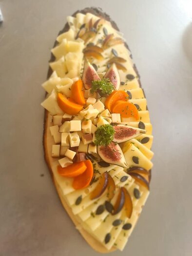 Ein kunstvoll angerichtetes Käsebrett mit verschiedenen Käsesorten, Feigen, Aprikosen und Kürbiskernen. Es ist ansprechend dekoriert und eignet sich perfekt für eine Feier oder als Snack. | © Köll Fleischfachgeschäft &amp; Catering