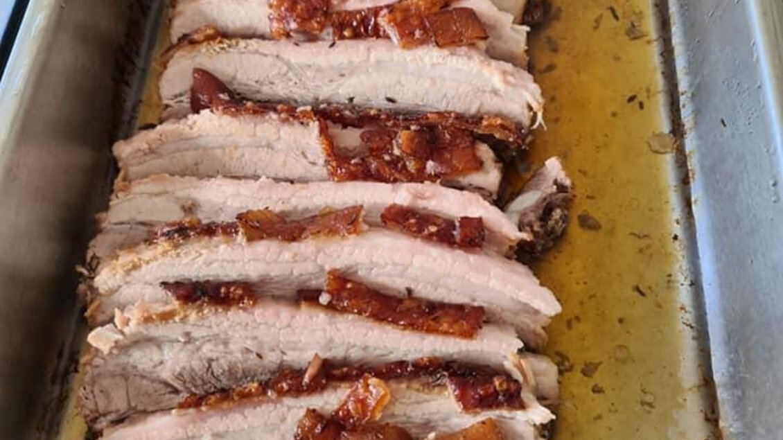 Zarte, in Scheiben geschnittene Fleischstücke mit knuspriger Kruste liegen in einer Auflaufform. Saftige Marinade umgibt das Fleisch. | © Köll Fleischfachgeschäft &amp; Catering