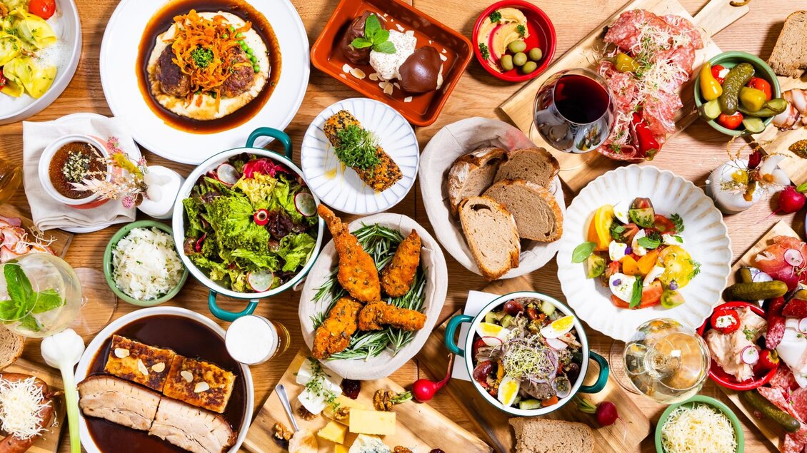  Große Auswahl an warmen und kalten Speisen, Salaten, Aufschnitt, Käse, Brot, Desserts und Getränken auf Holztisch | © Kaiser Greißler - Werner Krug