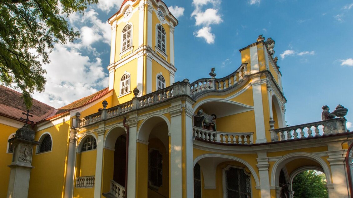 Gelbe Kalvarienbergkirche in Graz mit barockem Turm, Vorplatz und Bäumen bei Sonnenlicht | © Graz Tourismus-Harry Schiffer