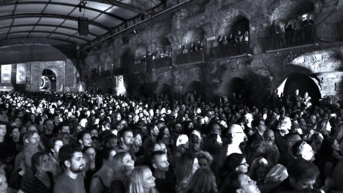 Schwarz-Weiß-Aufnahme einer Menschenmenge bei einem Konzert in der Kasemattenbühne Graz mit historischer Steinarchitektur | © Lucy Liu