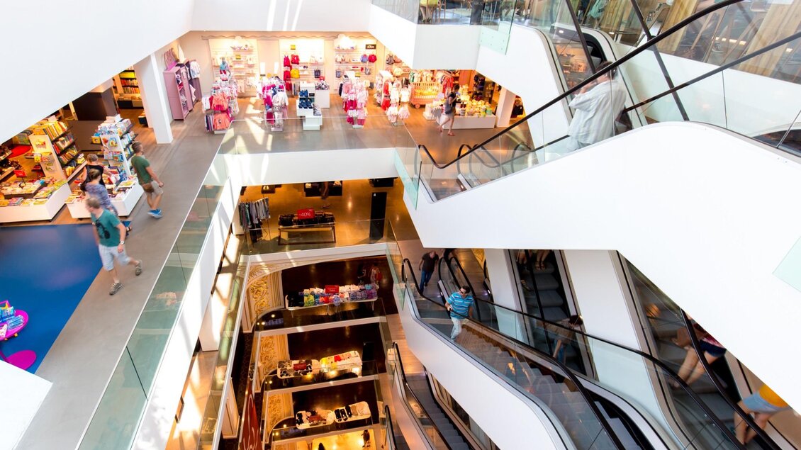 Blick in ein modernes Einkaufszentrum mit mehreren Etagen, Rolltreppen und Besuchern in Graz | © Graz Tourismus - Harry Schiffer