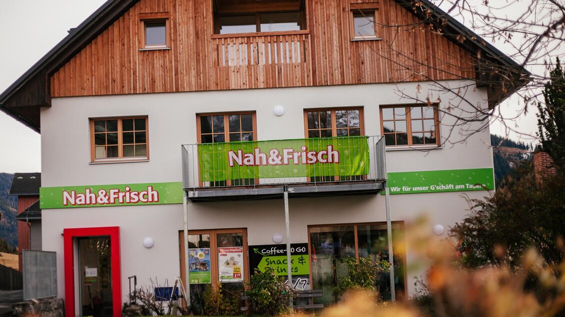 Ein Geschäft mit dem Namen "Nah&Frisch" in einem modernen Gebäude. Es verfügt über große Fenster und eine einladende Fassade. | © Damira Slodnjak