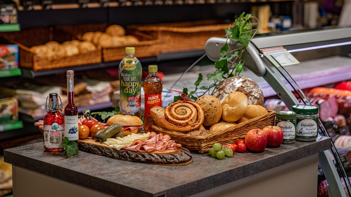 Ein Tisch mit verschiedenen Lebensmitteln, darunter Brot, Aufschnitt, Obst und Getränke. Die Präsentation ist ansprechend und einladend. | © Christine Höflehner