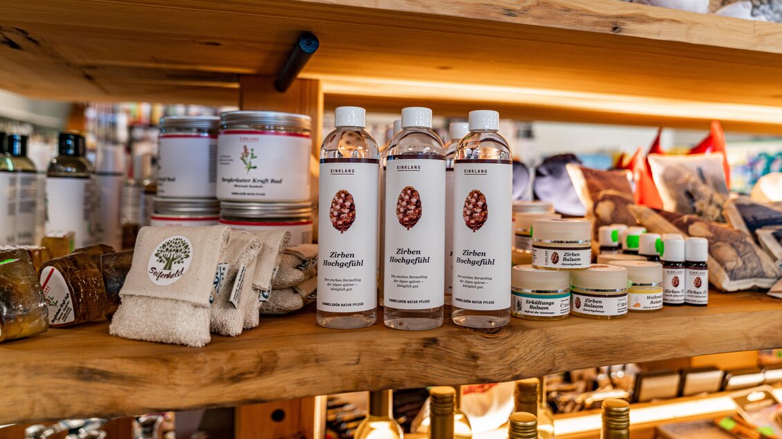 Eine attraktive Regale mit verschiedenen Produkten, darunter Wasserflaschen und Pflegeartikel. Die Oberfläche aus Holz gibt dem Arrangement ein warmes, einladendes Gefühl. | © Christine Höflehner
