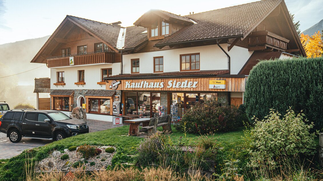 Ein traditionelles Gebäude mit einem Kaufhaus in den Alpen. Die Umgebung ist grün und die Atmosphäre ist gemütlich. | © Christine Höflehner