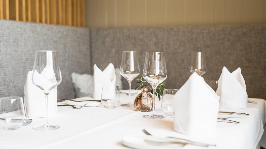Ein elegant gedeckter Tisch in einem Restaurant. Es sind Gläser, Besteck und gefaltete Servietten dekorativ angeordnet. | © Kehlberghof