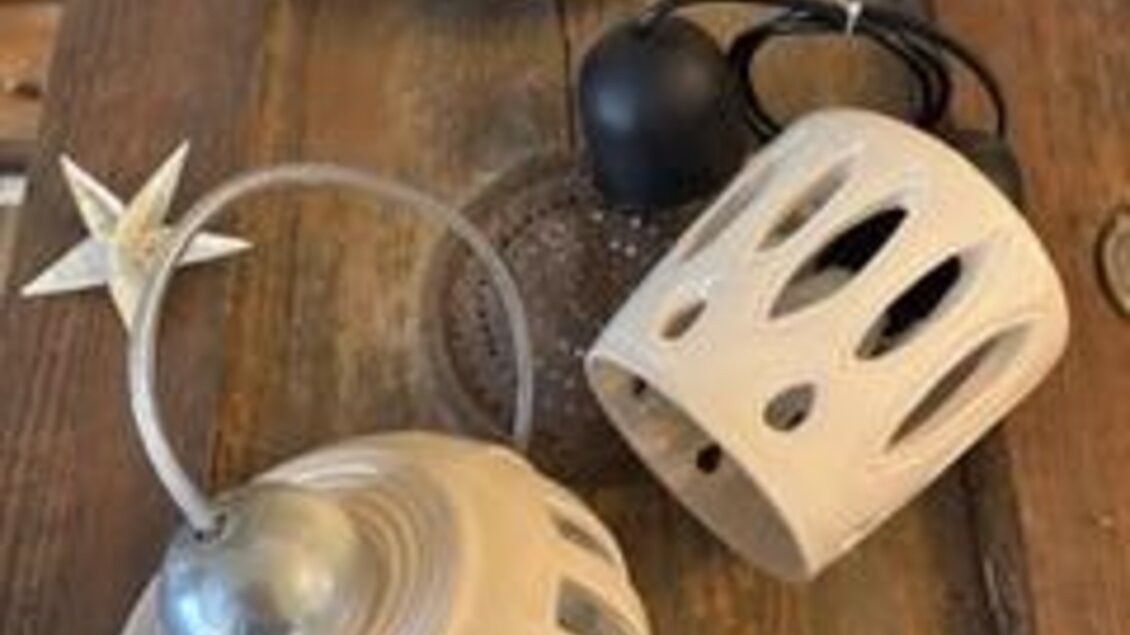 Drei dekorative Lampenschirme auf einem Holztisch. Sie haben ein schlichtes Design und sind umgeben von kleinen Sternen. | © Keramik Werkstatt Uhring