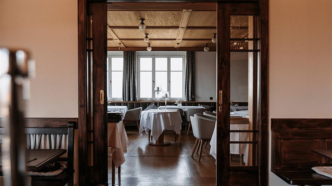 Ein elegantes Restaurant mit freundlicher Atmosphäre. Tische sind gedeckt und es gibt große Fenster mit Blick auf die Landschaft. | © Jaglhof