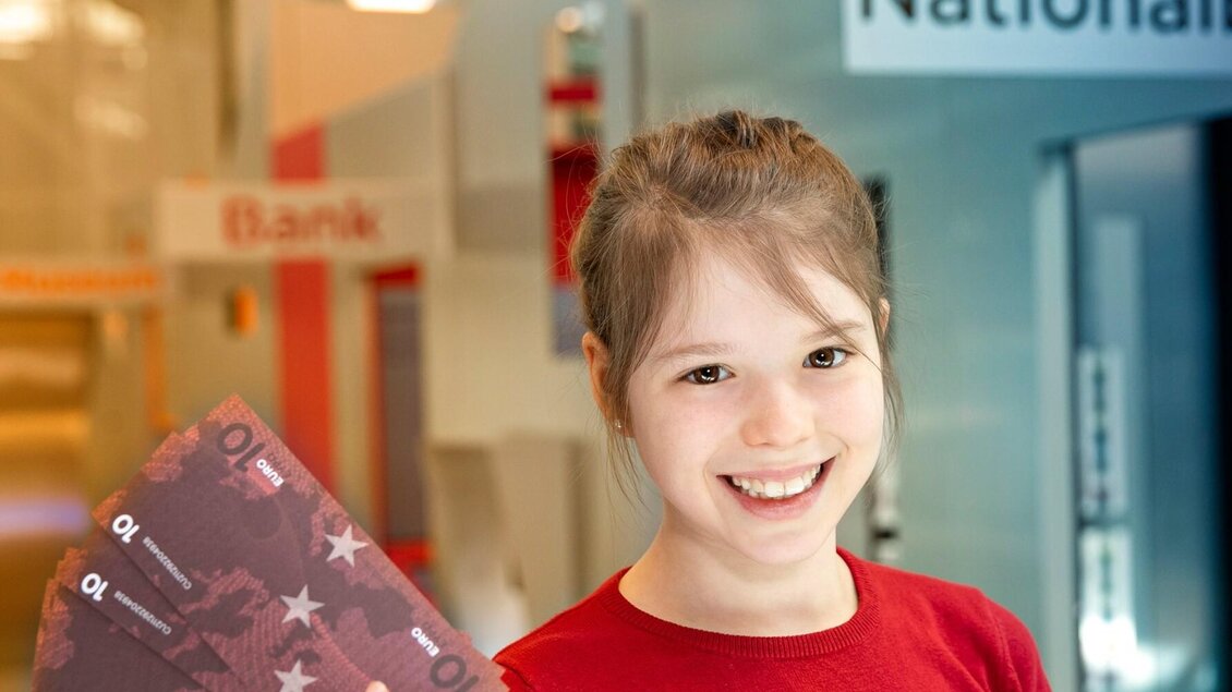 Mädchen hält Spielgeld in der Ausstellung „Stadt der Kinder“ im Kindermuseum Frida & Fred Graz | © FRida und freD-Hannes Loske