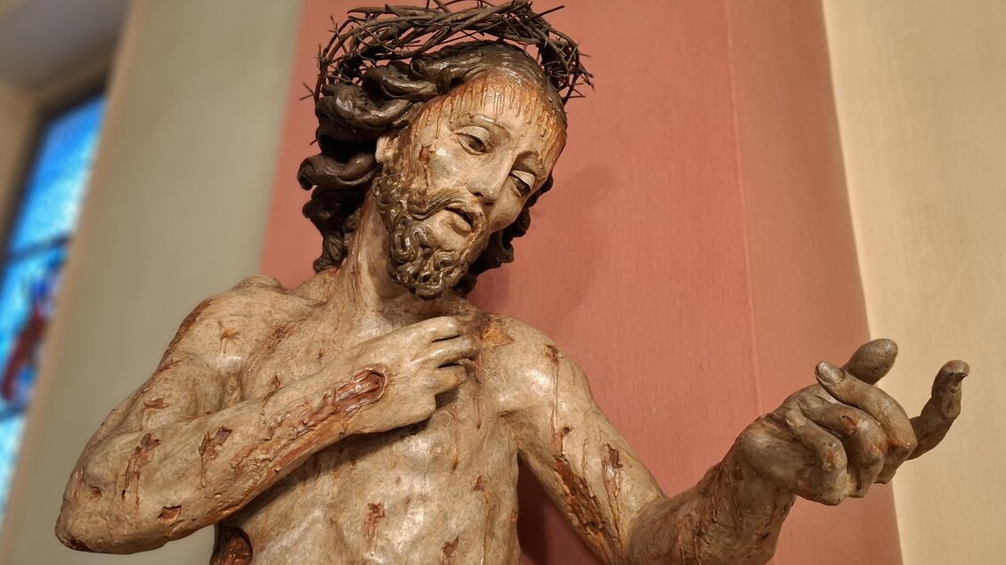 Eine detailreiche Statue von Jesus mit einer Dornenkrone. Er zeigt eine einladende Geste. | © Beate Koller