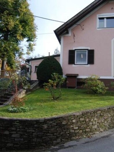 Ein charmantes Haus mit einer pinken Fassade und einem gepflegten Vorgarten. Der Eingang ist von einer niedrigen Mauer und einer Treppe umgeben. | © Fam. Fauland