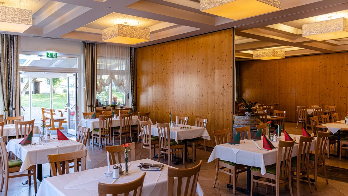 Ein gemütliches Restaurant mit weißen Tischen und Holzstühlen. Die Wände sind aus Holz und es gibt moderne Beleuchtung. | © Martina Siebenhandl
