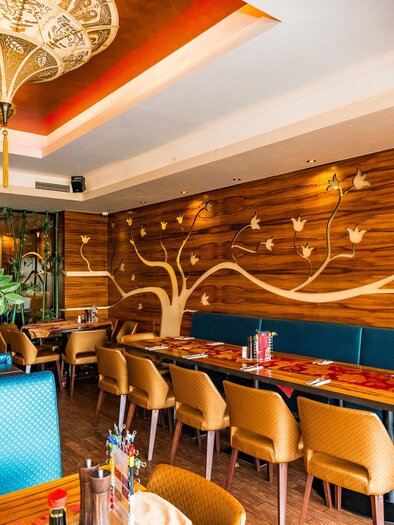 Ein stilvolles Restaurant mit gemütlichen Sitzplätzen und einer Holzdekor-Wand. Die Beleuchtung schafft eine einladende Atmosphäre. | © Region Graz - Mias Photoart