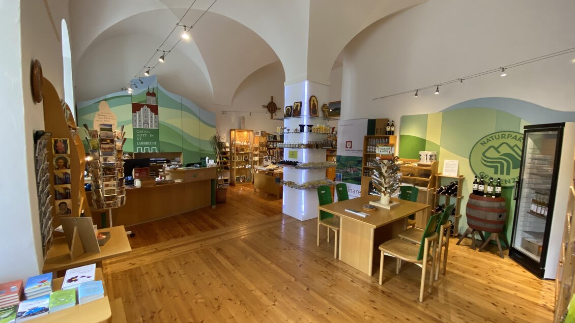 Ein einladender Laden mit Holzregalen und Tischen. Die Wände sind farbig gestaltet und es gibt verschiedene Produkte zu sehen. | © Benediktinertstift St. Lambrecht