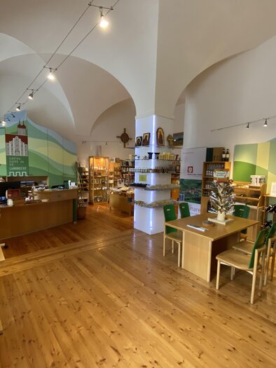 An inviting store with wooden shelves and tables. The walls are colorfully designed, and there are various products on display. | © Benediktinertstift St. Lambrecht