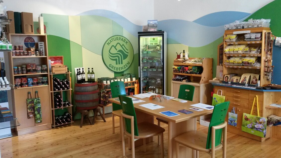 Ein gemütlicher Laden mit Holzregalen und Tischen. Auf den Regalen sind verschiedene lokale Produkte und Getränke präsentiert. | © Benediktinerstift St. Lambrecht