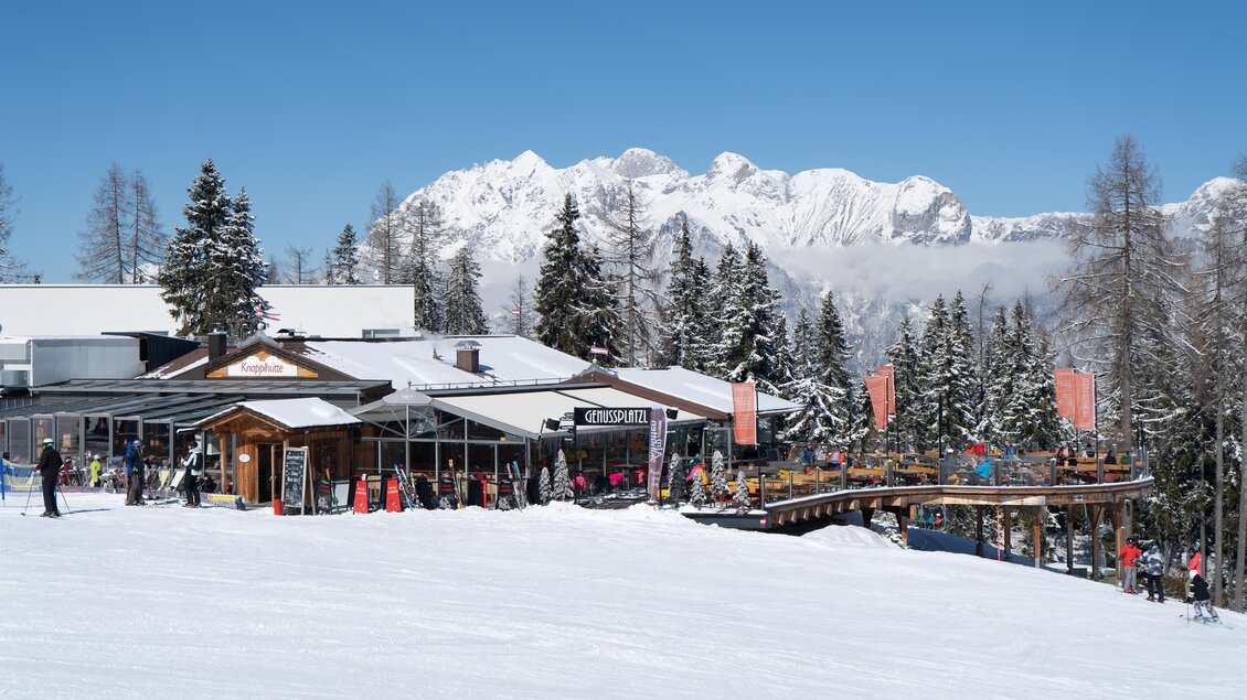 Knapplhütte am Hauser Kaibling mit Sonnenterrasse im Schnee, im Hintergrund die verschneiten Berge. | © Knapplhütte