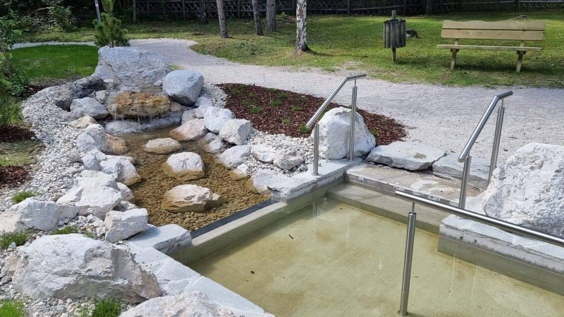 Ein ruhiger Wellnessbereich mit einem kleinen Wasserbecken und einem natürlichen Bach. Umgeben von Grünflächen und Felsen, bietet der Ort Entspannung in der Natur. | © Marktgemeinde Gröbming