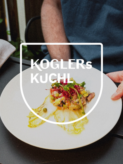 A plate with creatively arranged food, consisting of fresh ingredients and a colorful garnish. In the background, a cozy atmosphere can be seen. | © Johannes Kogler