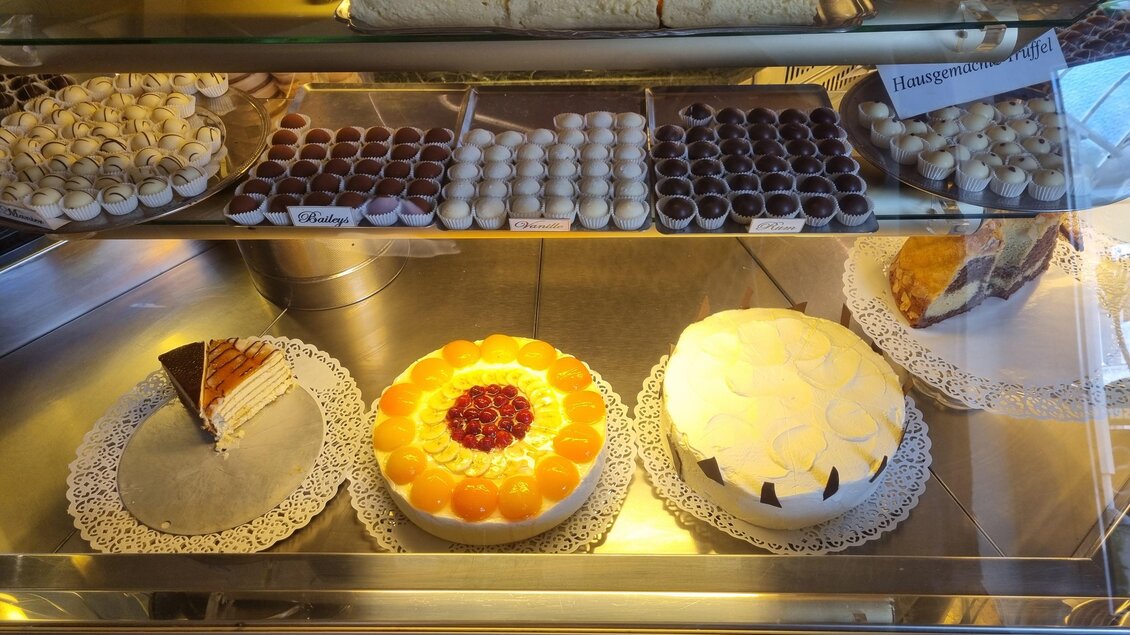Eine Auswahl an köstlichen Torten und Pralinen in einer Vitrine. Die Torten sind bunt dekoriert und wirken sehr appetitlich. | © Erlebnisregion Murtal