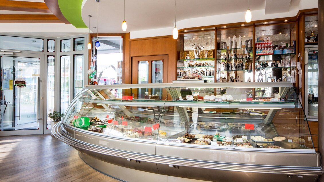 Eine moderne Eisdiele mit einer großen, gläsernen Vitrine voller verschiedener Eissorten. Der Innenraum ist hell und einladend gestaltet. | © TV Region Graz - Lunghammer