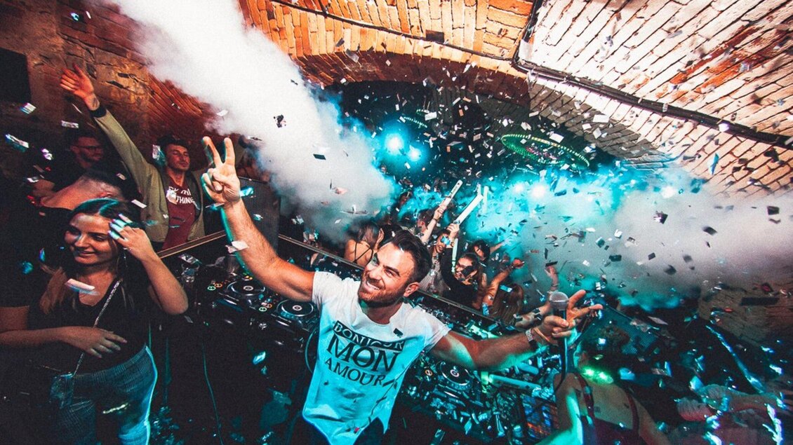 Eine lebhafte Partyszene mit tanzenden Menschen und buntem Konfetti. Die Atmosphäre ist energiegeladen und festlich. | © Kottulinsky