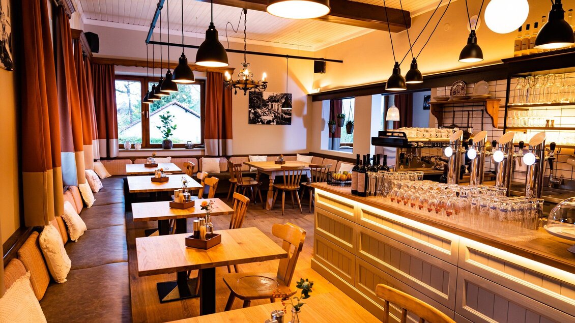 Ein gemütliches Restaurant mit Holzstühlen und Tischen. Die warmen Farben und die Beleuchtung schaffen eine einladende Atmosphäre. | © Kreuzwirt am Rosenberg - Werner Krug