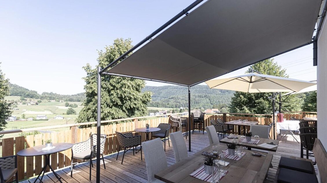 berdachte Holzterrasse mit Sitzplätzen und Panoramablick beim Wirtshaus Kreuzwirt in Thal. | © Joachim Grubelnik