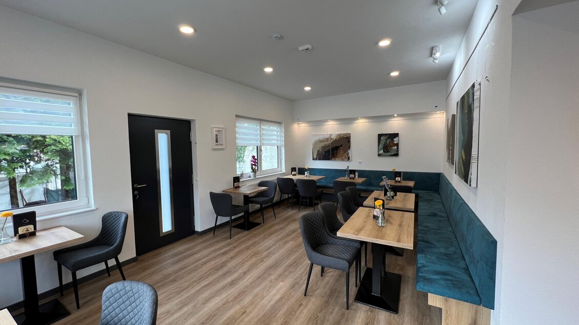 Ein modernes Café mit hellen Wänden und gemütlichen Sitzplätzen. Große Fenster sorgen für viel Tageslicht und eine einladende Atmosphäre. | © Andreas Albrecher