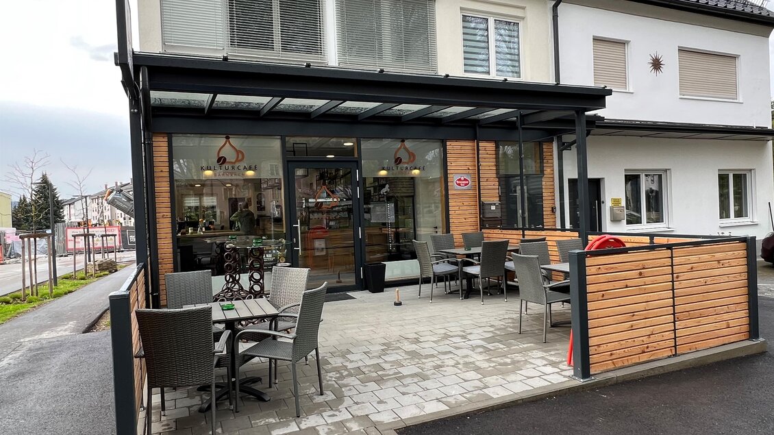 Ein modernes Café mit einer einladenden Außenterrasse. Die Glasfront und der Holzrahmen verleihen dem Gebäude eine freundliche Atmosphäre. | © Andreas Albrecher