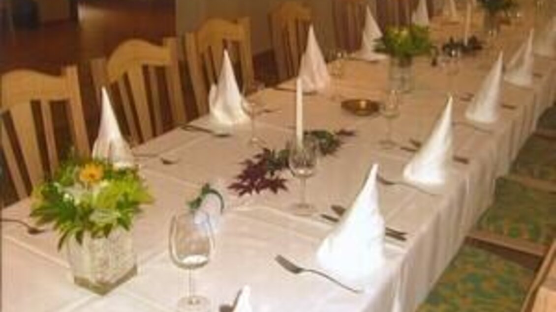 Ein festlich gedeckter Tisch mit weißen Tischdecken und dekorativen Servietten. Auf dem Tisch befinden sich Blumen und Kerzen für eine einladende Atmosphäre. | © Landgasthaus Kaiser