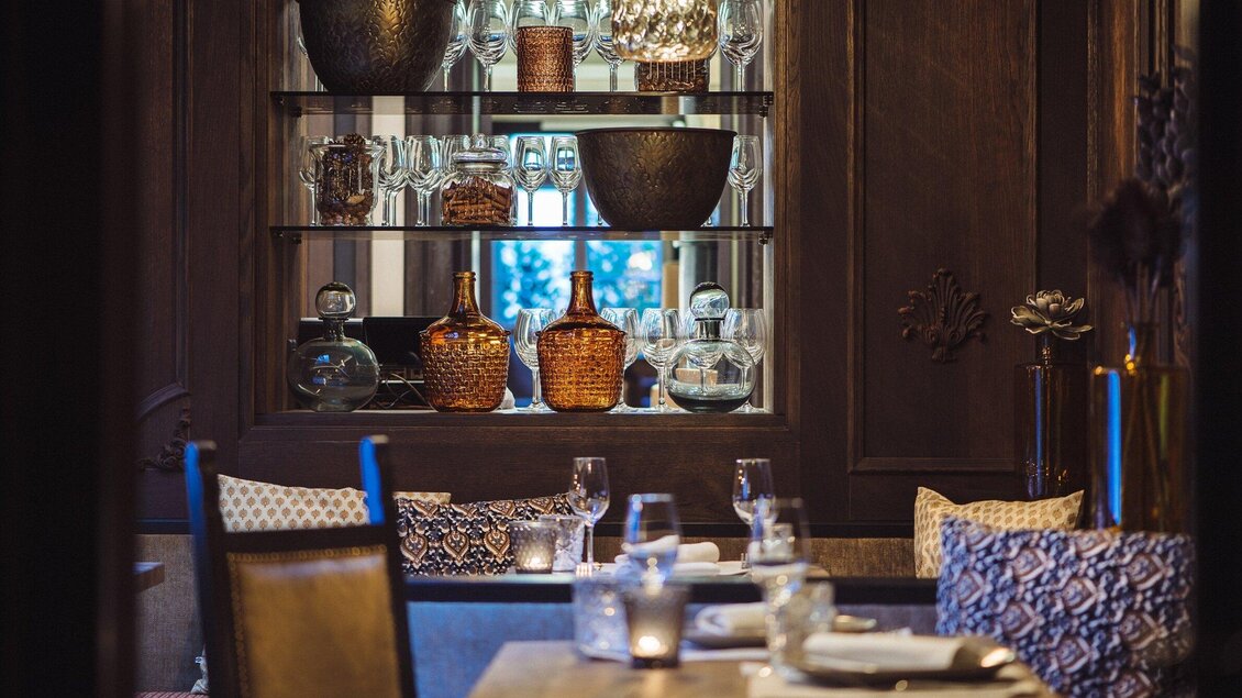 Ein gemütliches Restaurant mit eleganter Einrichtung. Im Hintergrund sind stilvolle Gläser und dekorative Gefäße sichtbar. | © Landhauskeller