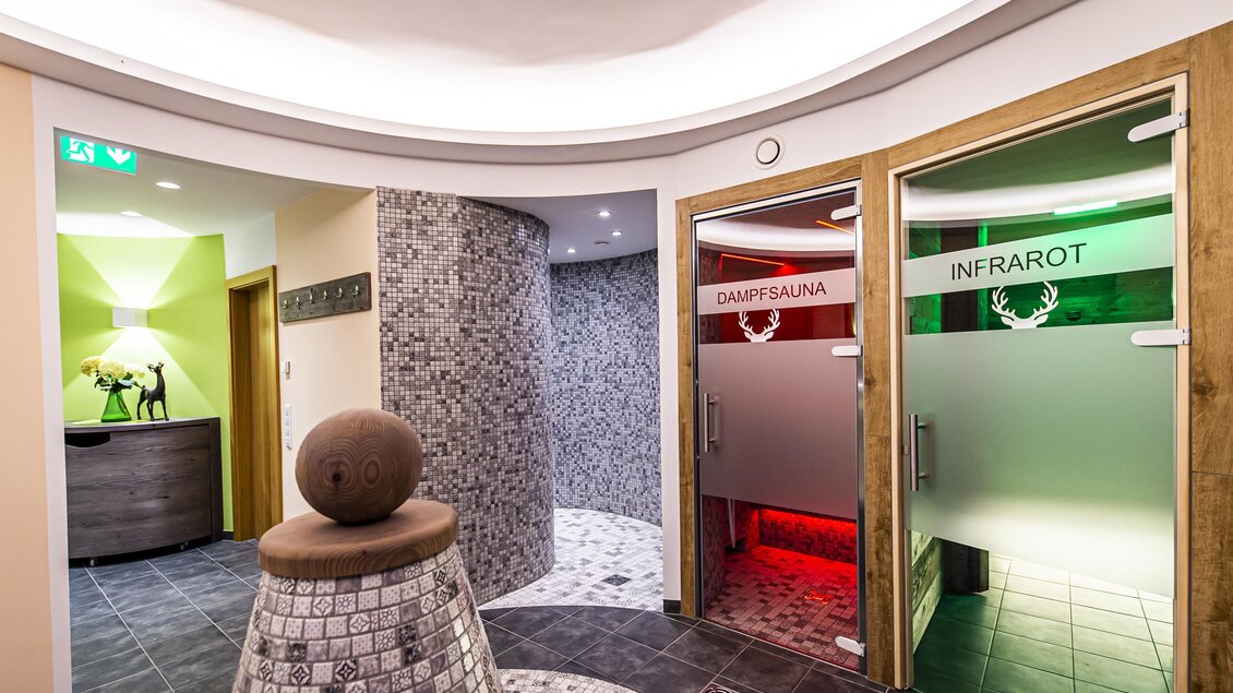 Ein heller Wellnessbereich mit zwei Saunen, die als Dampfbad und Infrarot beschriftet sind. Die Wände sind mit modernen Fliesen gestaltet und die Beleuchtung schafft eine entspannte Atmosphäre. | © Landhotel Timmerer