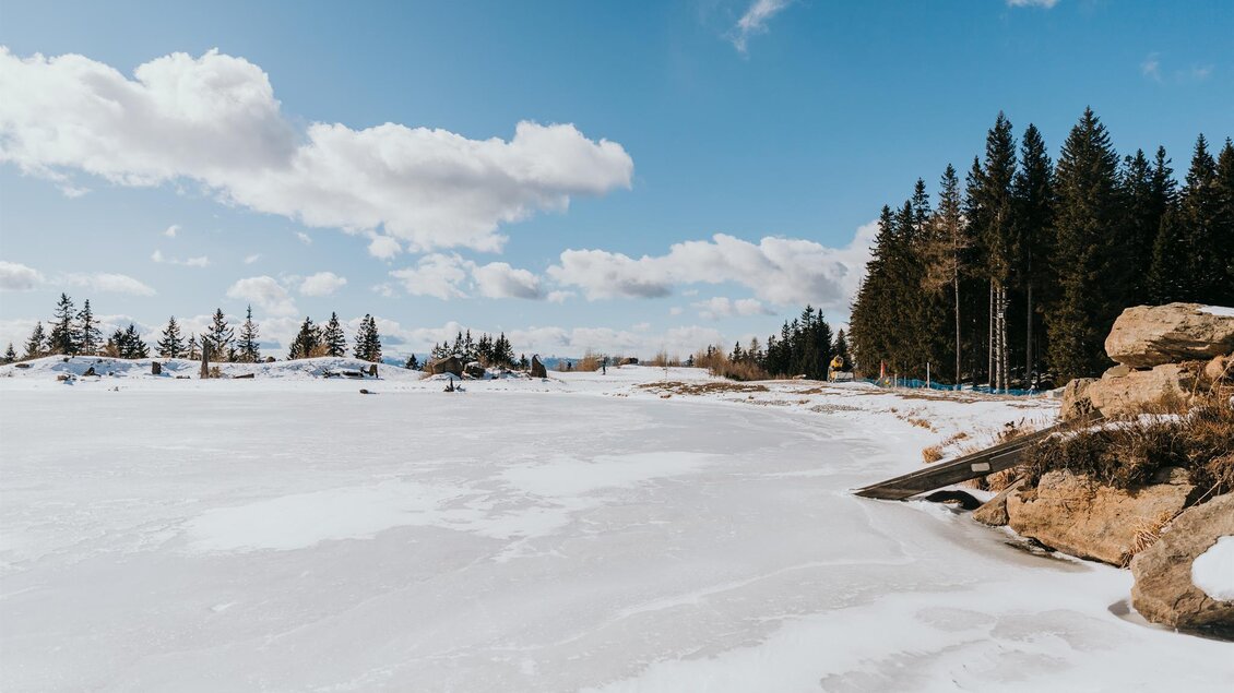 Eine winterliche Landschaft mit viel Schnee und einer klaren blaue Himmel. Im Hintergrund sind Föhren und einige Felsen zu sehen. | © Schilcherland Steiermark