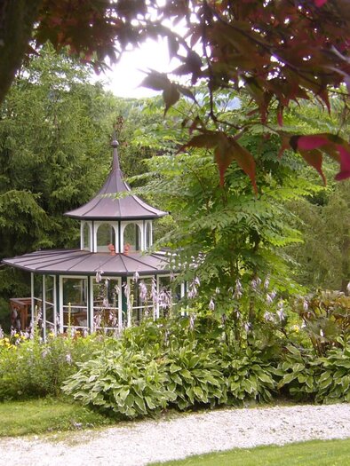 Verzierter Pavillon im Legensteinpark Graz, umgeben von Blumen und Gehölzen. | © Legenstein