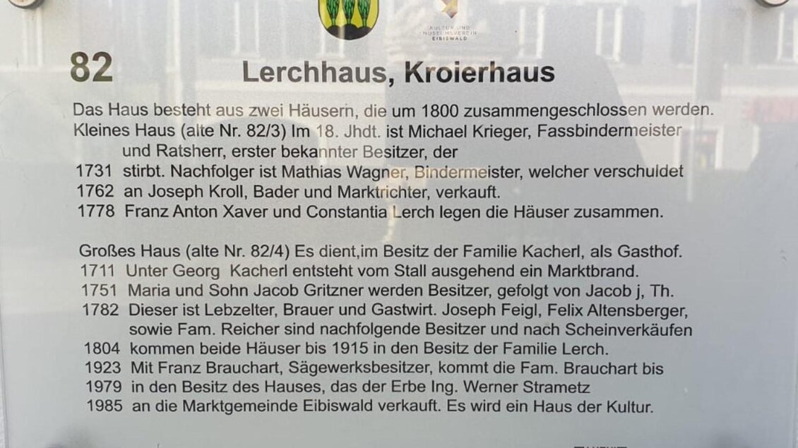 Ein Informationsschild über das Lerchhaus und Kroierhaus. Es beschreibt die Geschichte und die Eigentümer der beiden Häuser. | © Sabrina Prattes
