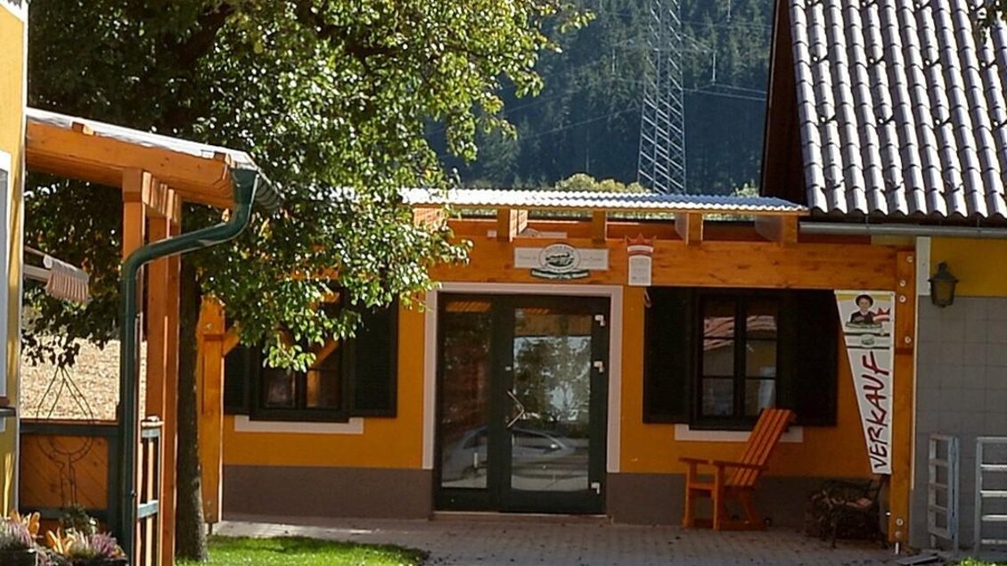 Ein kleines Verkaufsgebäude mit einer einladenden Tür und einem orangefarbenen Stuhl. Umgeben von Bäumen und einem ruhigen Hintergrund. | © Erlebnisregion Murtal