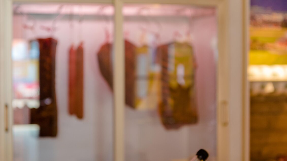 Ein Korb mit verschiedenen Wurst- und Fleischprodukten steht im Vordergrund. Im Hintergrund ist eine Kühleinheit mit weiteren Fleischwaren zu sehen. | © Erlebnisregion Murtal