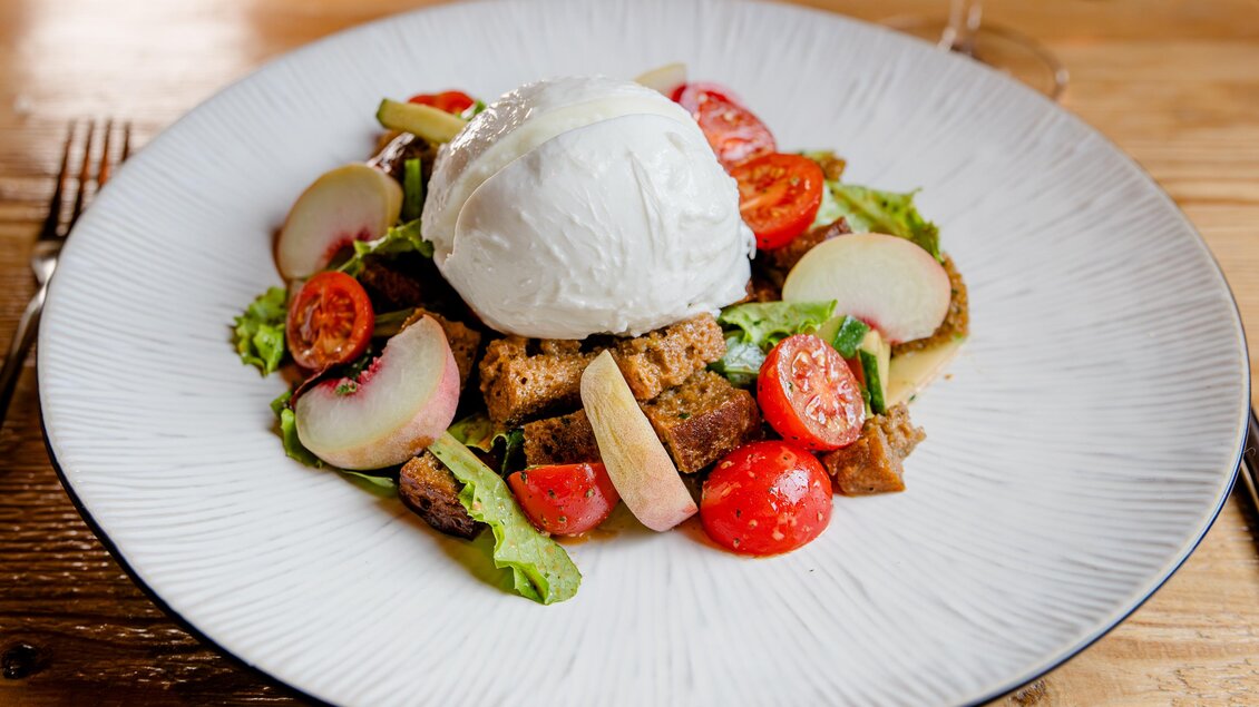 Ein frisch zubereitetes Gericht mit Salat, Kirschtomaten und geröstetem Brot. Obenauf liegt ein pochiertes Ei. | © Region Graz - Mias Photoart