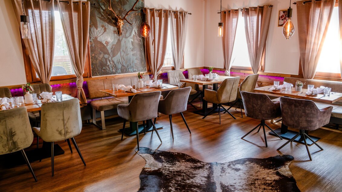 Ein elegantes Restaurant mit modernen Möbeln und warmem Holzdekor. Große Fenster sorgen für viel Licht und eine gemütliche Atmosphäre. | © Region Graz - Mias Photoart
