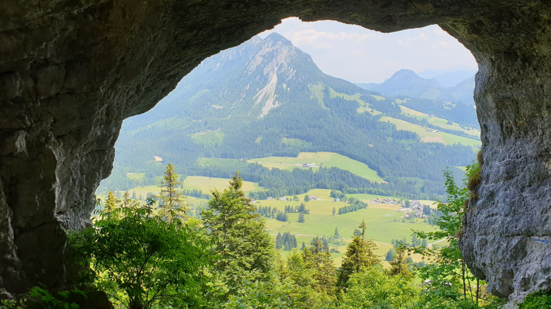 Ein Blick aus einer Höhle auf eine grüne Landschaft mit Bergen im Hintergrund. Die Natur ist üppig und lädt zum Erkunden ein. | © Daniela Casari