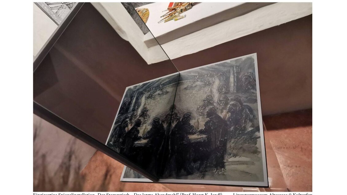 Eine einzigartige Spiegelinstallation zeigt ein Kunstwerk mit einer düsteren Szene. Der Fokus liegt auf der reflektierten Darstellung in einem modernen Ausstellungsrahmen. | © Kulturfux