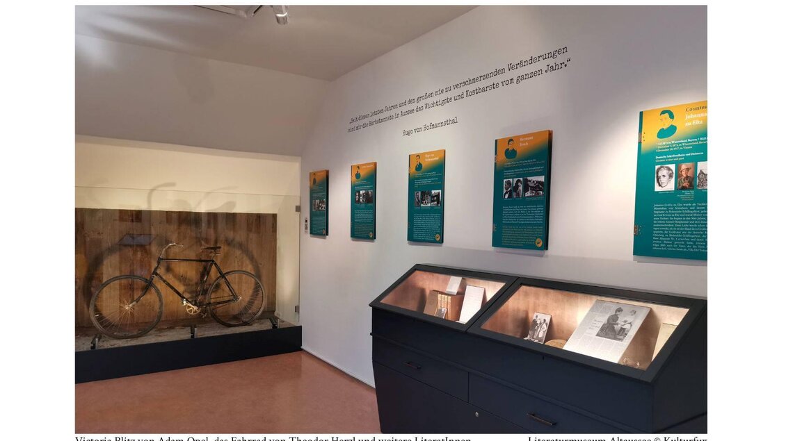 Ein Ausstellungsraum mit einem historischen Fahrrad von Adam Opel und Informationstafeln an der Wand. Der Raum zeigt zudem weitere literarische Exponate. | © Kulturfux